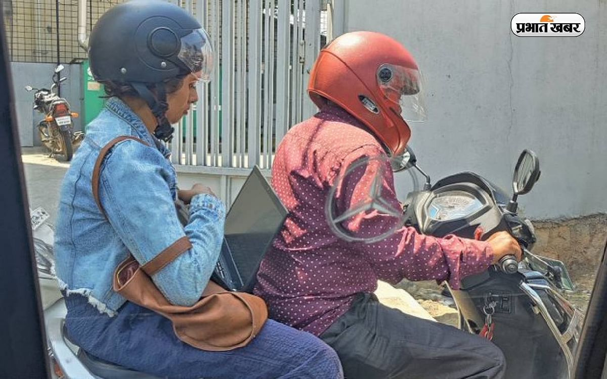 Woman stuck in traffic started working by opening laptop while sitting behind scooty, debate started on social media